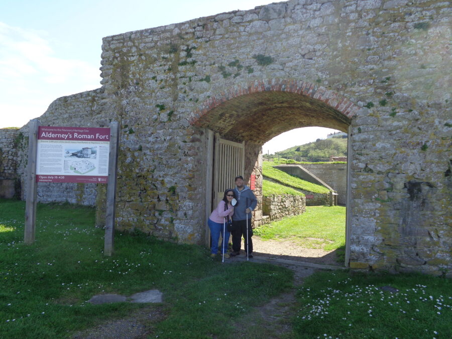 Tony and Tatiana in the substantial stone entrance gate to Alderney's Roman Fort known locally as The Nunnery. The fort is thought to have been built in around 350 AD. It covered 40 square metres (430 sq ft) with rounded corners where bastions were built. Built of stone and Roman concrete, the south, west and north curtain walls are still standing. Parts of the east, north and south walls remain of the tall tower that once stood inside the walls.