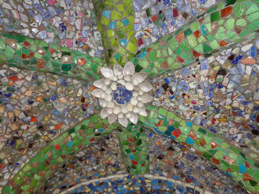 Flower decoration on the ceiling of the Little Chapel. The petals of the flower are formed from sea shells with a blue and white Willow pattern plate in the centre. Bands of green pottery fragments extend from the flower.