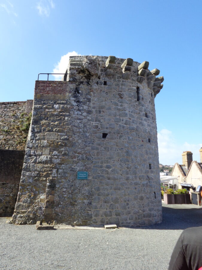 The Gunners' Tower at Castle Cornet. According to an attached sign this stone tower dates from around 1435. The tower has a semi-circular profile. It was the first tower at the castle designed to take cannon. There are protruding stone supports at the top, perhaps for defence purposes, or to support a roof.