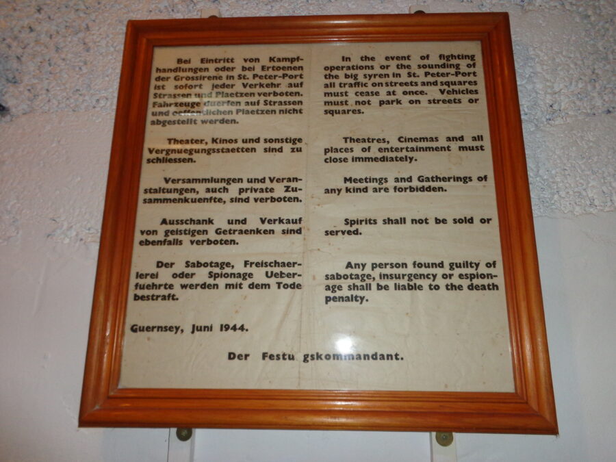 A framed German military declaration providing instructions to residents of Guernsey should hostilities occur. It dates from June 1944. The text is in German and English. It includes:
"Theatres, Cinemas and all places of entertainment must close immediately."
"Meetings and Gatherings of any kind are forbidden."
"Any person found guilty of sabotage, insurgency or espionage shall be liable of the death penalty."