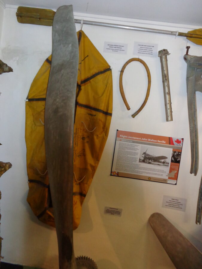 A collection of items displayed on a wall inside the German Occupation Museum. They include a one-man dinghy and paddles. According to the information board these were probably taken from a fighter plane based in Guernsey. There is also a fuel pipe and gauge tube, which were taken by islanders from a German Heinkel bomber, which crashed near Guernsey airport in 1940.