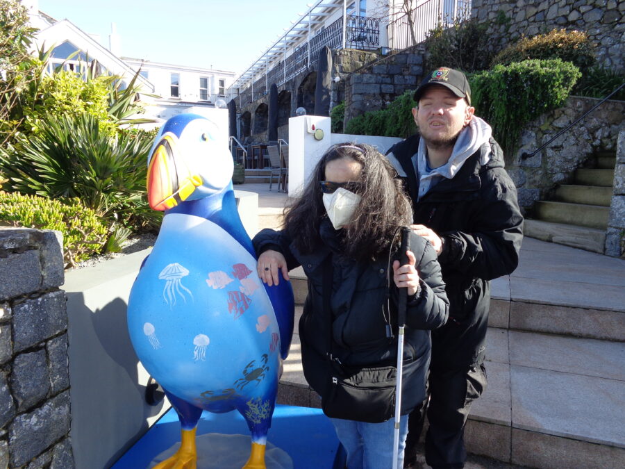 Tony and Tatiana next to Puff the puffin. This larger than life-sized fibreglass puffin sculpture is one of 60 that were decorated by local artists, community groups, and schools. It was part of an event organised by the GSPCA and Autism Guernsey between April and August 2023. In August 2023 the sculptures were auctioned raising over £98,000 for the two charities.