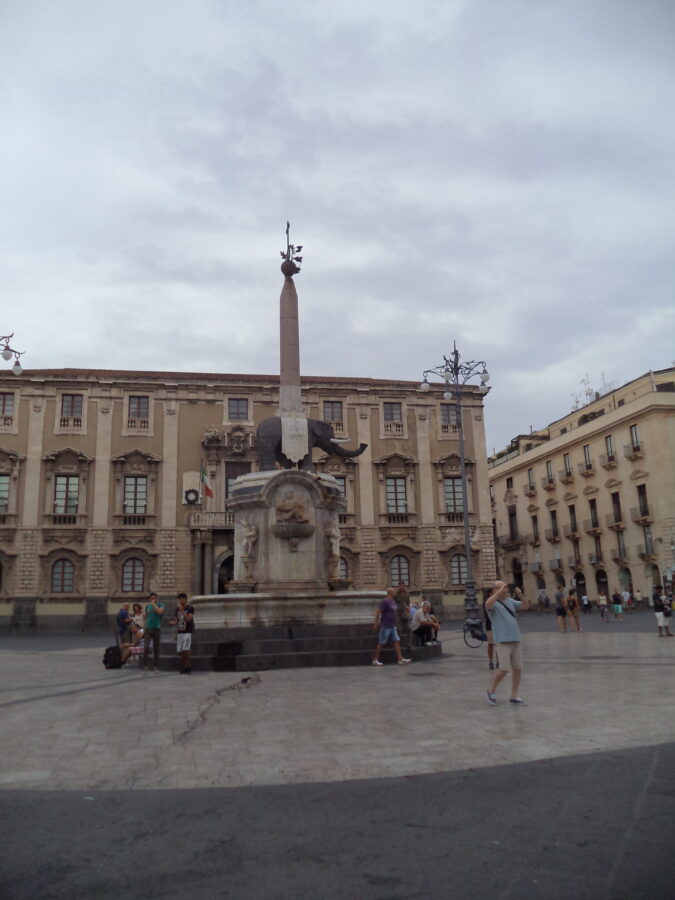 The Elephant Fountain (Fontana dell'Elefante) standing in the centre of historic Piazza dell Duomo. The fountain's central feature is an elephant carved in black basalt and standing on a pedestal. On the elephant's back is a 3.66 metre high Egyptian-style obelisk. The fountain was designed by architect Giovanni Battista Vaccarini between 1735 and 1737. The building in the background is the late 17th century Palazzo degli Elefanti which today houses the Town Hall.