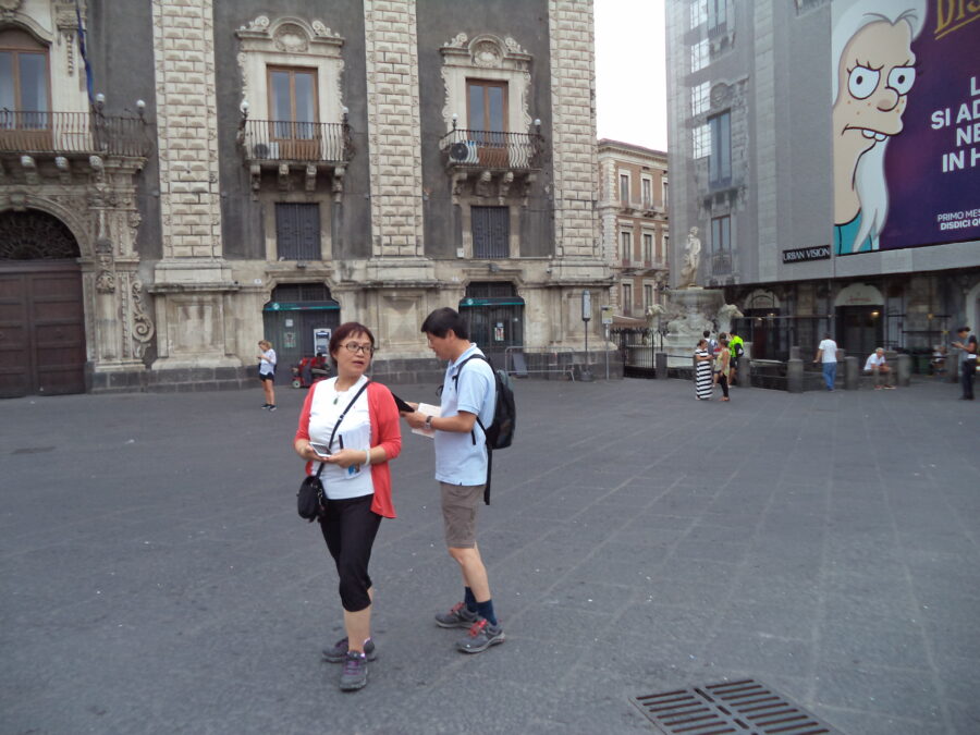 The monumental Sicilian Baroque Palazzo del Seminario dei Chierici (Palace of the Seminary of the Clerics) which faces on to Piazza dell Duomo close to the cathedral. The Amenano Fountain can also be seen on the right side. The current building, originally used for training clerics, was built after the 1693 earthquake that devastated the city. Construction began under architect Alonzo di Benedetto and was continued in 1757 by Francesco Battaglia. The building was later used as military barracks, and is today civic offices.
