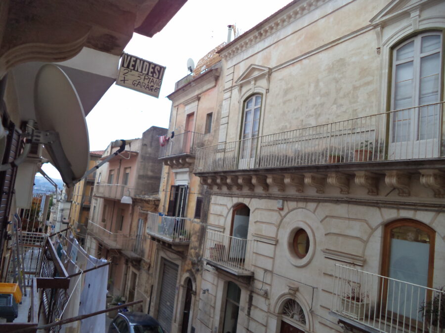 View from a balcony at the hotel where Tony and Tatiana stayed. Looking downhill along a fairly narrow residential street. The houses are mostly three storeys high and most have balconies. Washing is drying from some of the balconies.