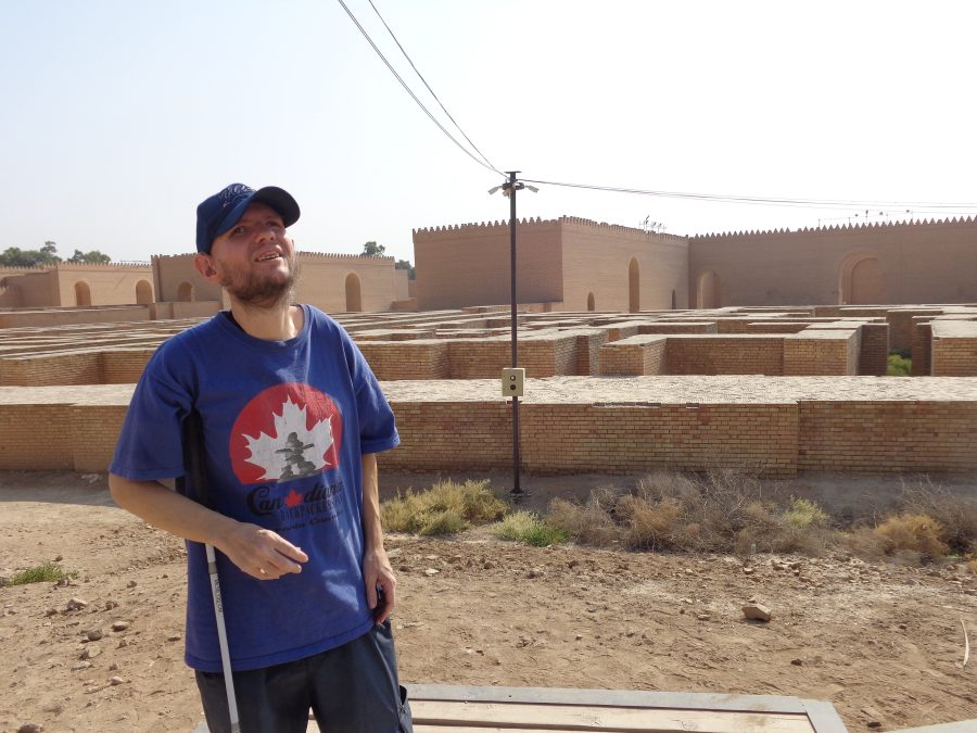 Tony with a dense grid of brick walls extending behind him. These walls appear to be built of modern bricks but likely mark the layout of the ancient city. Some of these walls are a metre or more in thickness. Further away are taller crenellated walls with several large arched doorways passing through them. This is one of the areas of ancient Babylon that was reconstructed under Saddam Hussain’s rule. The walls might be part of the Southern Palace of Nebuchadnezzar, which was one of the buildings partially reconstructed. The palace had 250 rooms and five courtyards.