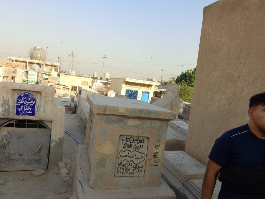 Again in Wadi-us-Salaam cemetery. A man can be seen half in shot to the right. In the distance at last five domes can be seen on the skyline, likely belonging to different mosques in Najaf city. 