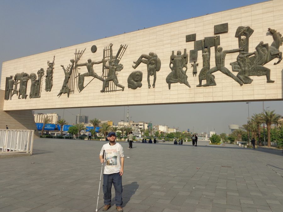 Tony stood in Liberation Square. This is Baghdad's largest and most central square located in the al-Rusafa district on the eastern banks of the Tigris river. In the background, spanning across the width of the square, is the huge Freedom Monument. This modernist relief mural was completed in 1961 and was built to commemorate Iraq's declaration of independence. It consists of 14 bronze castings, representing 25 figures, on a stone slab, raised six metres off the ground. The monument is 10 metres in height and 50 metres in length. The abstract figures, which are in bas-relief, are intended to evoke Babylonian, Assyrian and Arab artworks. The monument is intended to be read as a verse of Arabic poetry from right to left. It depicts events in Iraq's history up to the 1958 revolution. The monument was the work of husband and wife sculptors Jawad Saleem and Lorna Selim.