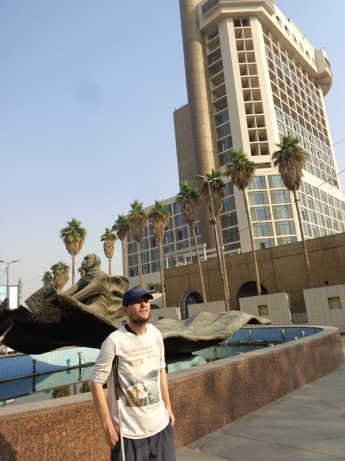 Tony again stood next the the magic carpet fountain and sculpture but facing the other way. In the background is another tall hotel. This is the Ishtar Hotel (formerly known as the Ishtar Sheraton Hotel). It is 99 metres in height and was built in 1982: it is the third tallest building in Baghdad. The hotel was regularly used by foreign journalists during the 1991 Gulf War and the 2003 invasion of Iraq. Following the 2003 invasion the hotel became a target for mortar or rocket fire and in 2005 it was seriously damaged by a bomb attack and was closed for more than a year afterwards. It was renovated in 2011.