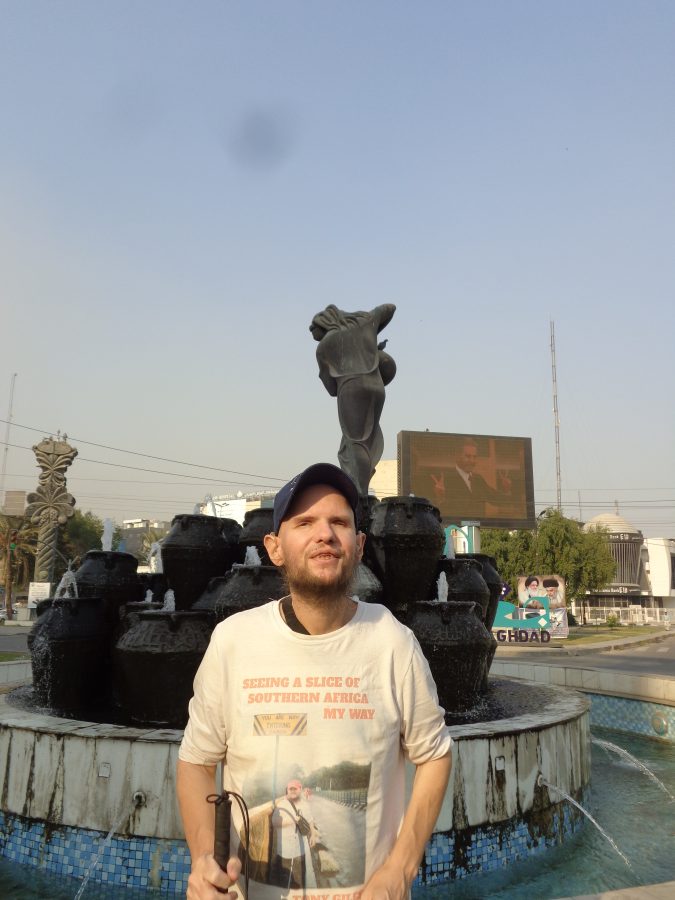 Tony now stood at the other side of the Kahramana sculpture. The jars with water bubbling out can be seen behind with Morgiana standing on top of them. In the background to the left another artwork can be seen. This is a bronze depiction of a date palm. A large video screen mounted on a pedestal is also in view. 