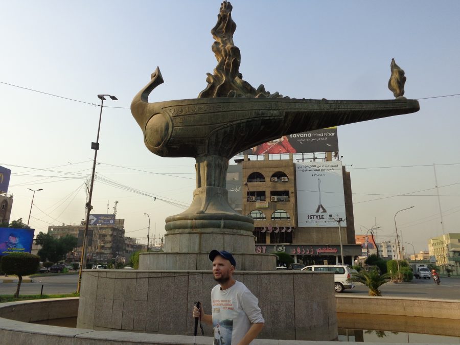 Tony stood in front of the Magic Lantern (Al Fanous El Sehri) sculpture. This large bronze monument is shaped like a traditional oil lamp, with sculpted flames emerging from the top, and a bird-like figure at the front. The lantern is set upon a high circular stone pedestal with a pool of water around the base. It is located in the middle of a roundabout on al-Karaada street. The sculptor was Mohammed Ghani Hikmat and it was inaugurated in 2011. It is part of a set of four monuments commissioned by the Mayor of Baghdad.