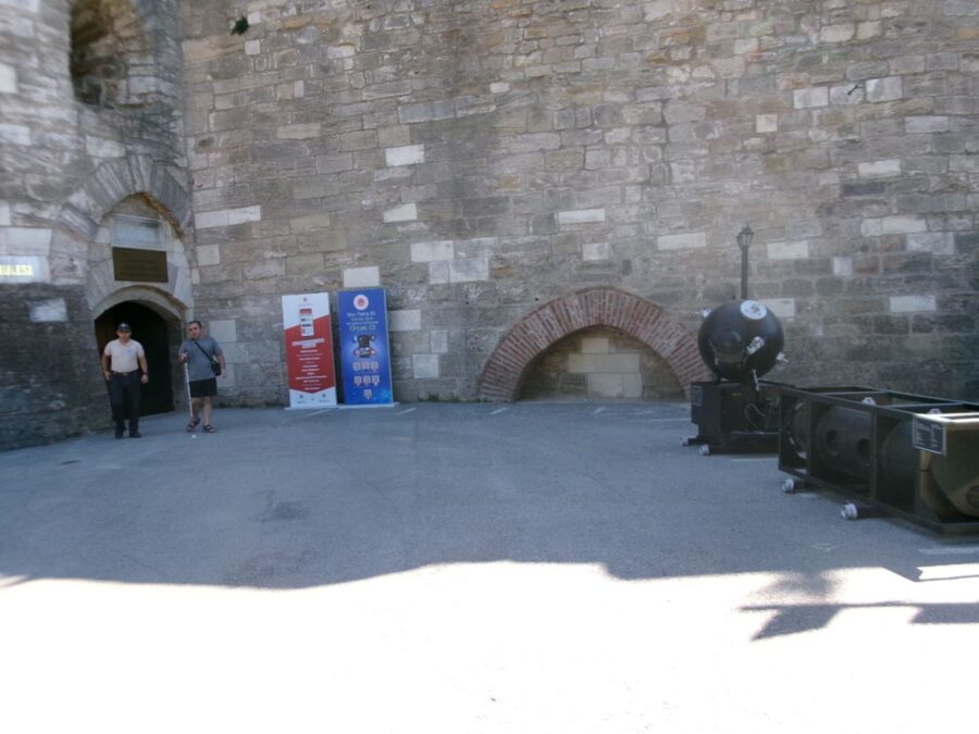 Courtyard outside Çimenlik Castle (also known as Kale-i Sultaniye) which today houses Çanakkale Military Marine Museum (Naval Museum). The arched entrance doorway to the museum is to the left where a high stone wall joins with a stone turret. Çimenlik Castle was built in 1452 to control the Dardanelles strait, and it remained in use to 1915, when it was bombarded by the British Navy. It now contains the Çanakkale Military Marine Museum, which displays old weaponry, military equipment and several Turkish ships, used in World War I and beyond.